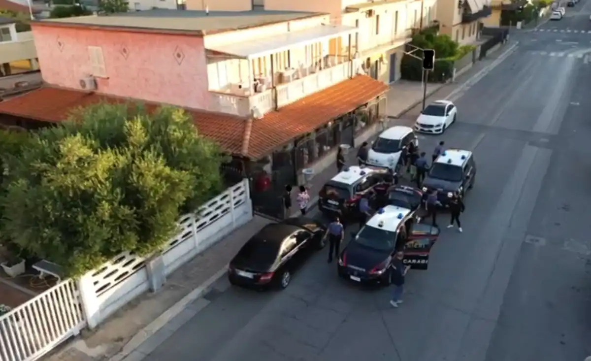 Macchine dei carabinieri fuori di un'abitazione durante l'operazione che ha condotto in arresto 11 persone per reati legati allo spaccio di droga a Latina