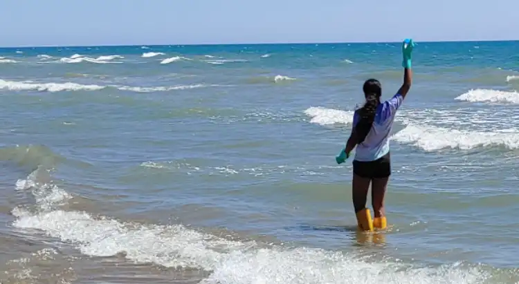 Volontaria di Goletta verde esegue campionamento dell'acqua in corrispondenza della foce del fosso Cavallo Morto, Lungomare delle Sterlizie ad Anzio, Lazio.